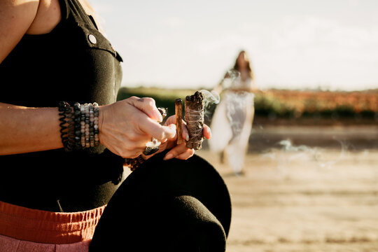 Woman in desert lighting palo santo and sage