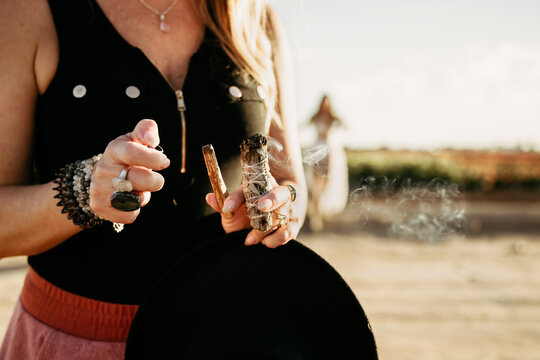 Woman lighting palo santo and sage