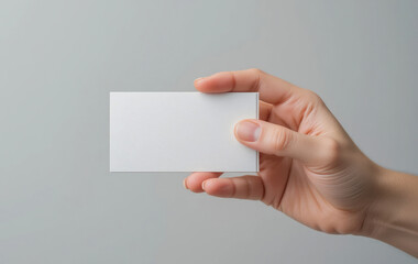 Fototapeta premium Holding Blank Business Card in Hand Against Neutral Background Mockup