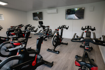 A row of stationary bikes are lined up in a gym