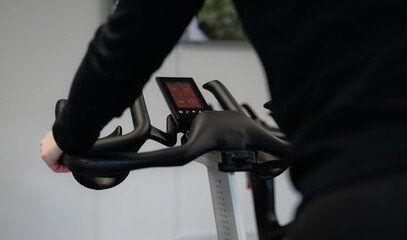 Obraz premium A person is riding a stationary bike with a digital screen showing the time