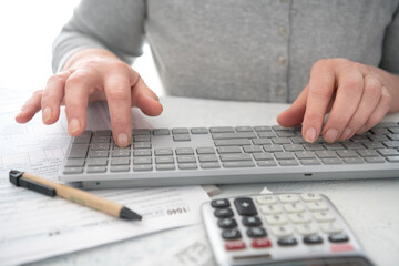 woman fills out a 1040 tax return.