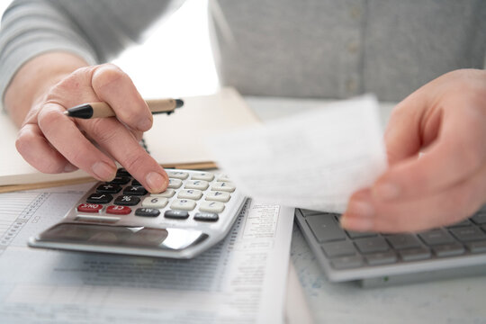 woman uses a calculator to do financial calculations or file a tax return.