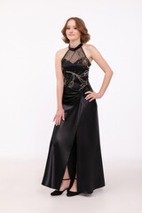 Fototapeta premium An Elegant Woman Dressed in a Stunning Black Evening Dress Featuring a Chic Slit