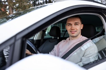 Driver behind steering wheel of modern car, view from outside