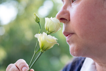 Female nose lights up with delight savors Lisianthus, springtime and beauty nature, while also...