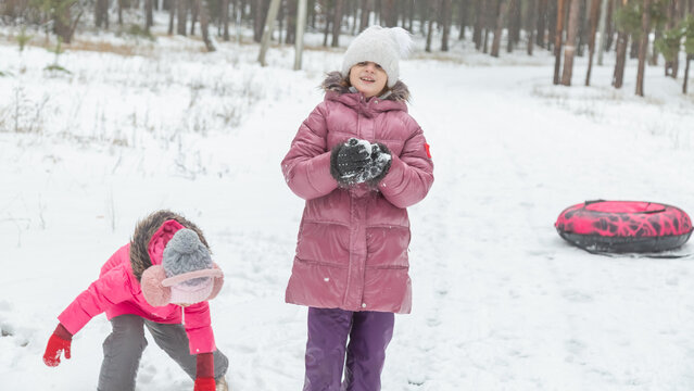 Playful family enjoying snowball fight in snowy winter park
