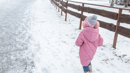 Little girls walking in park on snowy winter day