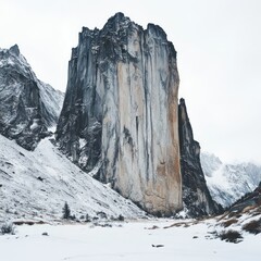 A dramatic tall rock formation towers over a snowy landscape