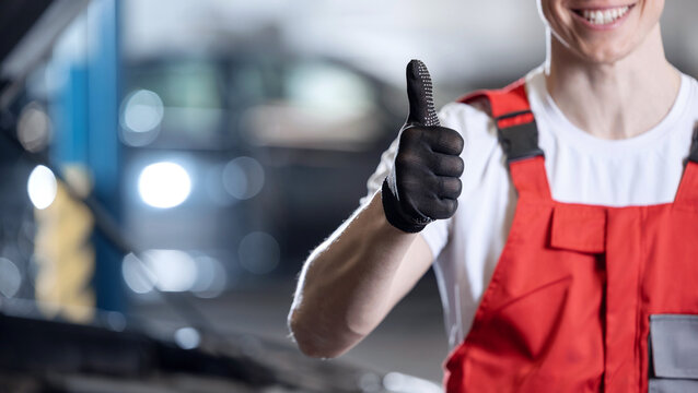 Auto mechanic giving thumbs up in repair shop, banner car fix garage