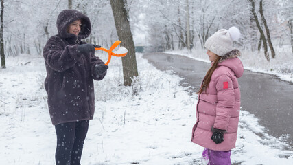 Grandmother playing with granddaughters at park in winter