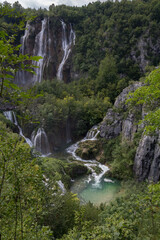 A tranquil view of the small waterfalls at Plitvice Lakes National Park, surrounded by lush greenery.