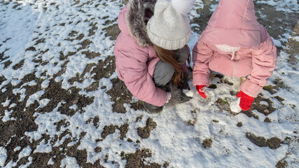 Two little girls playing on the playground on a winter day