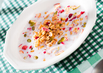 Oatmeal with dried fruit and milk in a plate. Tasty breakfast