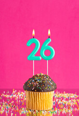 Birthday cupcake with number 26 candle - Celebration card on fuchsia background.
