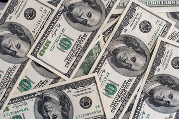 Scattered US hundred-dollar bills creating symbolizing financial prosperity, cash wealth, and economic power. Concept of money abundance, economic success, and business finance. High quality photo