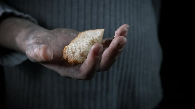 Homeless person hands with bread. A homeless female hands hold bread in her dirty hands during starvation time.