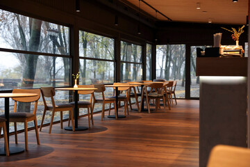 Stylish cafe with large windows and comfortable furniture. Interior design