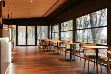 Stylish restaurant with large windows and comfortable furniture. Interior design