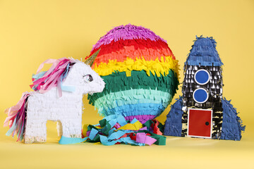 Different bright colorful pinatas on yellow background