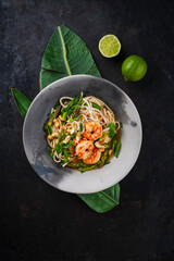 Authentical Asia style ramen noodle soup with prawns and cashew nuts served as top view in a design bowl
