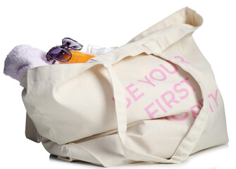 Beach bag with sunglasses, sun cream, sun lotion, towel isolated on white background.