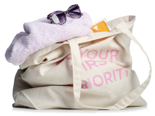 Beach bag with sunglasses, sun cream, sun lotion, towel isolated on white background.