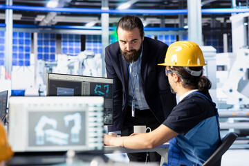 Solar panels plant manager giving feedback to employee on optimizing efficiency after analyzing data. Photovoltaics factory supervisor overseeing man working on innovative solar cells design prototype