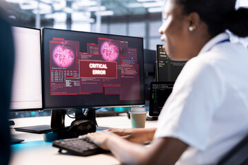 African american computer scientist in server hub working to protect equipment from hacker. Woman...