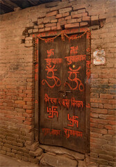 An ancient wooden door with symbols drawn on