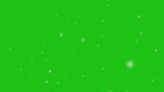 Realistically Animated Snow Particles On A Green Background. It's Like A Gathering Of Thousands Of Fireflies. Cold Particle Precipitation. Isolated falling snowfall on green chroma key Background.