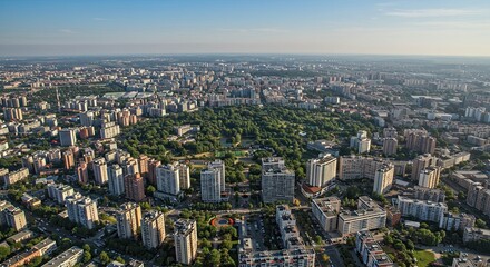 Fototapeta premium Aerial view of a lush urban park surrounded by city buildings at sunset