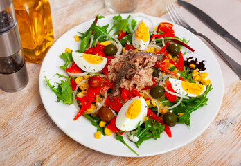 Traditional Catalonia food, salad xato with codfish, eggs and olives on a ceramic plate
