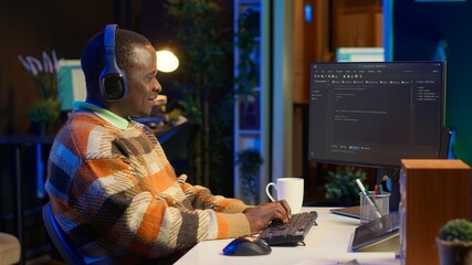 African american computer scientist in home office programming code on pc. Freelancing developer...