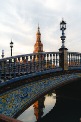 Naklejka premium Ornate bridge and tower at plaza de Espana, seville - architectural marvel at dusk. Spain Square, Plaza de Espana