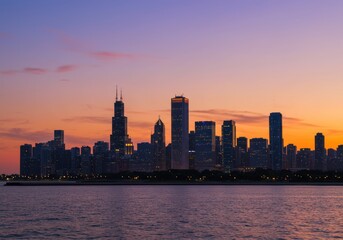 Obraz premium Chicago skyline at dusk with illuminated skyscrapers reflecting in lake michigan