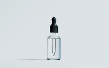 Clear glass dropper bottle with black cap on a white background. The bottle is partially filled with a clear liquid.  Simple product shot