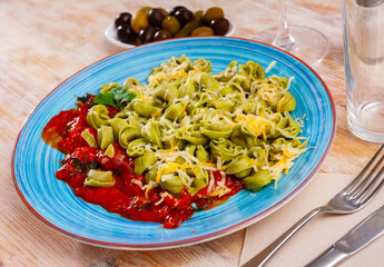 Plate of delicious freshly boiled tortellini with tomatoe sauce and cheese