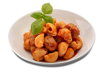 Lumaconi pasta with meatballs and tomato sauce and basil leaves in plate isolated