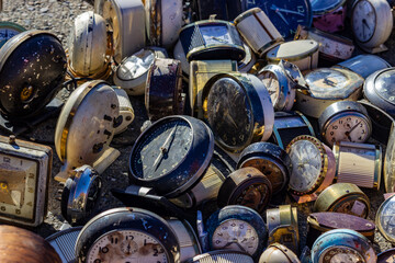 Large pile of vintage and antique alarm clocks in various states of rust and disrepair, showcasing...