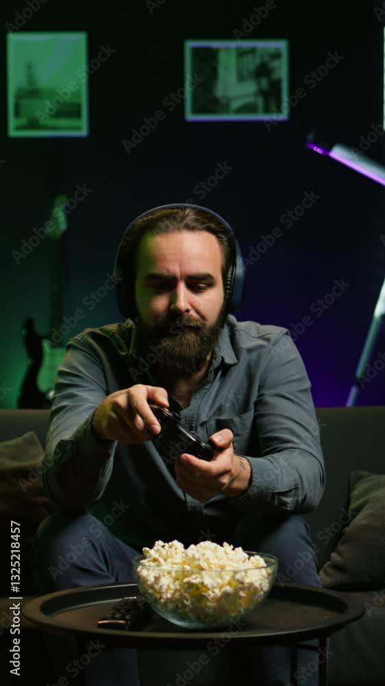 Poster vertical video man looking in disbelief at tv screen while playing videogames, receiving game over m
