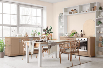 Interior of light kitchen with dining table, counters and shelf unit