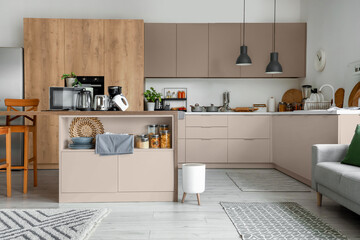 Interior of light kitchen with modern appliances on wooden table