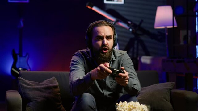 Man looking in disbelief at TV screen while playing videogames, receiving game over message on gaming console. Gamer upset after being defeated by rival players in online esports competition, camera A