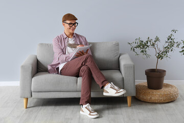 Male author with feather writing on paper at home