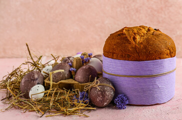 Delicious Easter cake with painted eggs and flowers on beige background