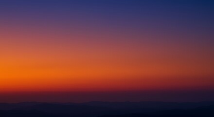 Fototapeta premium Fiery Sunset Over Silhouetted Mountains