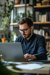 A businessman is seated at his laptop in an office, engaged in online planning, drafting proposals, and conducting research. He embodies creativity and professionalism as he works on his computer, br