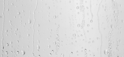 Water drops on light grey glass surface, top view