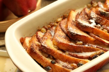 Freshly baked bread pudding in baking dish on table, closeup